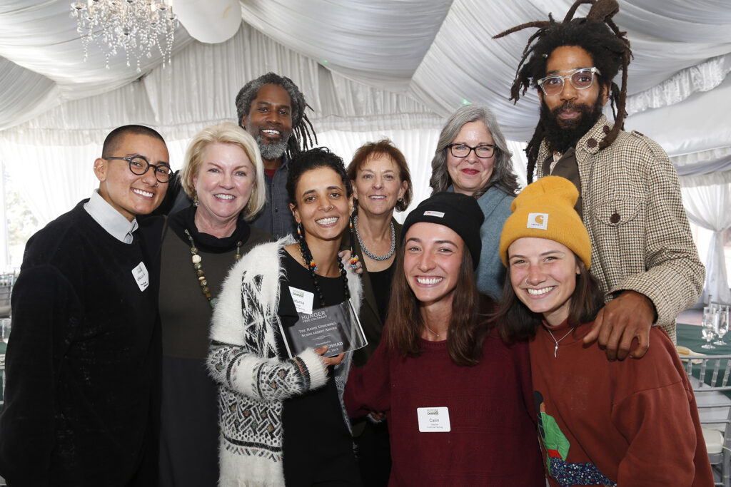 Group of people smile and pose for the camera at the Hungry for Change Summit. In the center is the Fatuma Emmad, the first recipient of the kathy underhill scholarship award